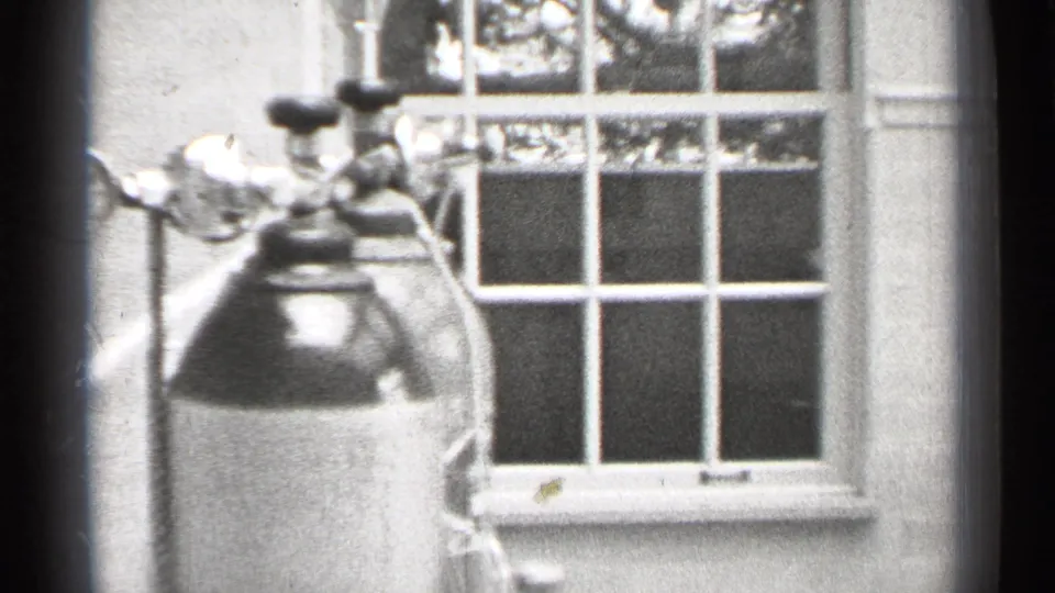 A gas cylinder or similar tank appears near a multi-pane window in the same black-and-white kitchen-like San Francisco interior.