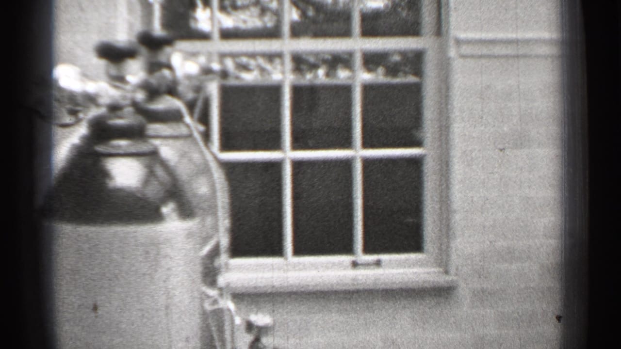 1944 San Francisco 8mm frame showing oxygen tanks near a multi-pane window in a plain clinical or institutional interior.