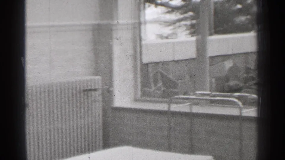 Soft 8mm frame from the clip showing an interior or window-side view before the doorway action in San Francisco metadata context.