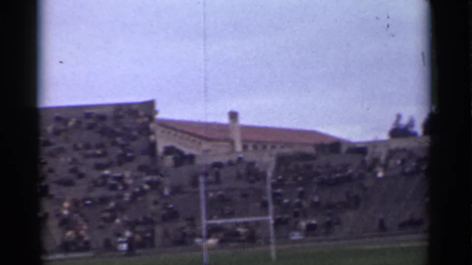 Wide 1944 San Francisco stadium view with dense spectators, a field goalpost, and red-tiled rooflines in the background.