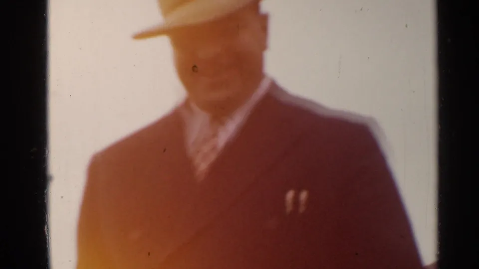 Close 1944 San Francisco home-movie view of the fedora-wearing man, softened by exposure flare and visible film wear.