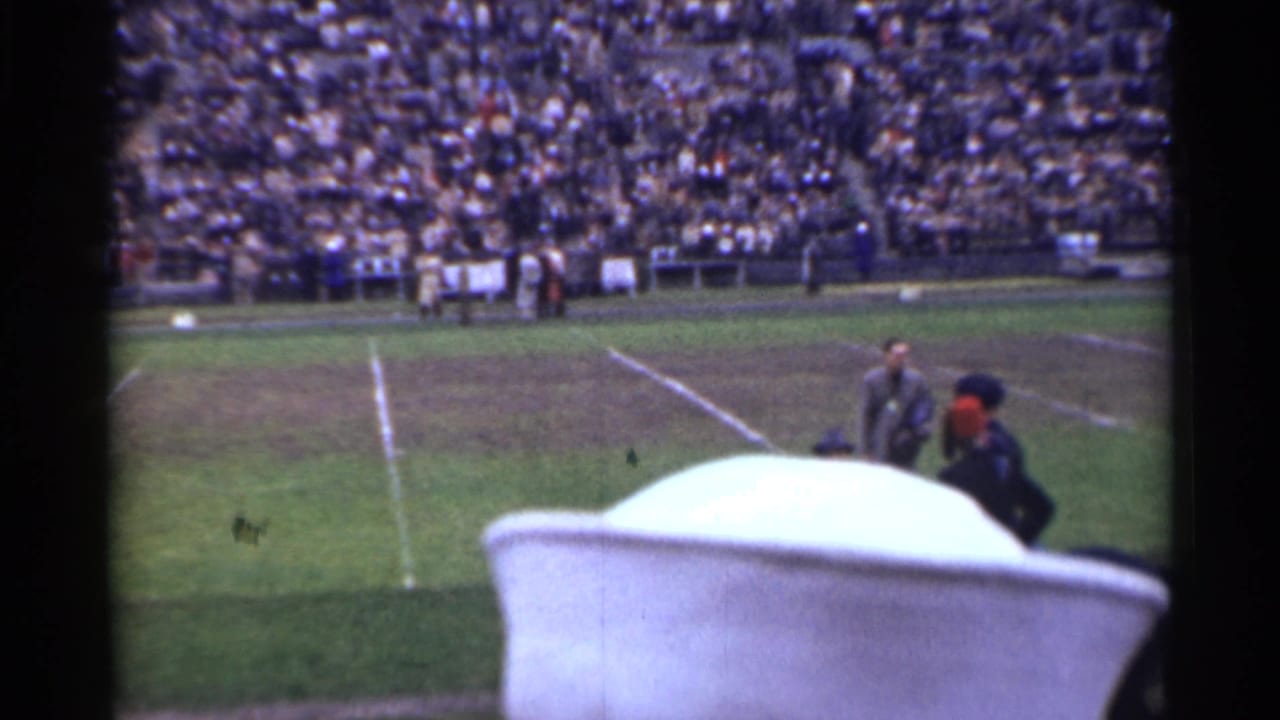 1944 San Francisco football scene with packed stadium seating, players on the field, and a large pale foreground obstruction near the camera.