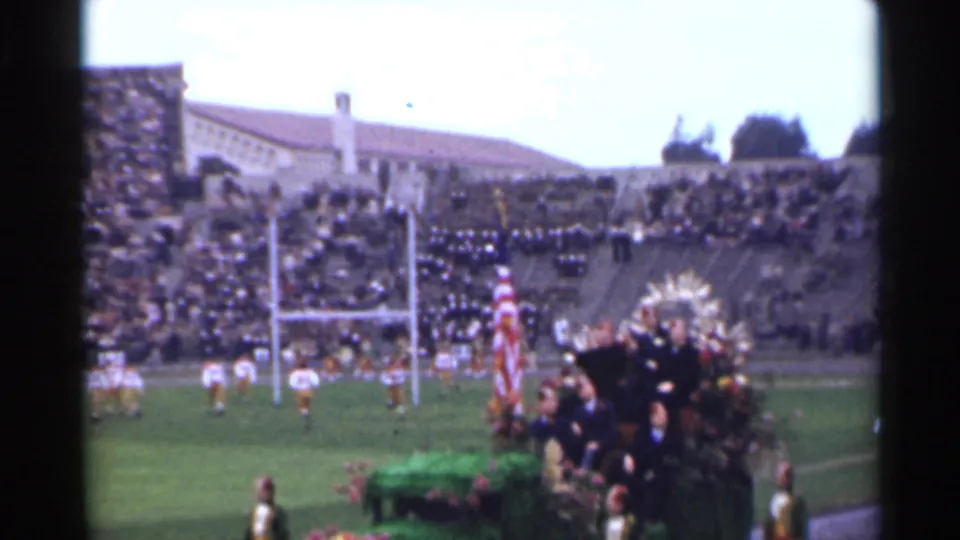 1944 San Francisco stadium view showing football players near goalposts beside a floral ceremonial platform and large American flag.