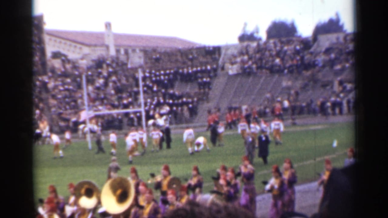 San Francisco 1944 8mm view of a crowded football stadium with players near the goalposts and marching band brass in the foreground.