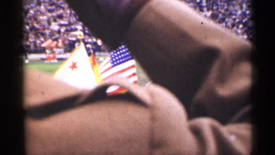 San Francisco 1944 football-event view with American and California flags partly obscured by a nearby spectator's coat.