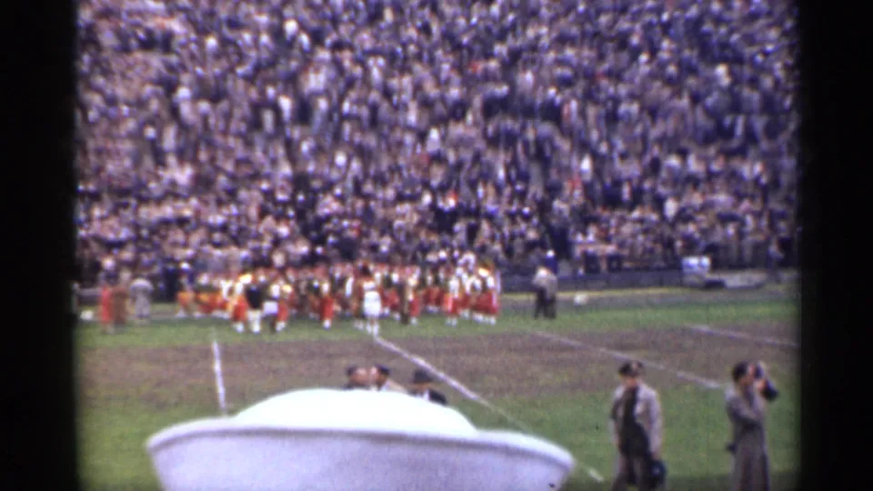 1944 San Francisco stadium view showing a marching band in red and white uniforms with a large crowd and sideline figures nearby.