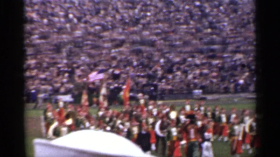 1944 San Francisco stadium scene with band members, flags, brass instruments, and a large crowd seen from the stands.