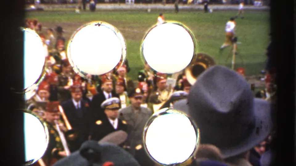 Close spectator-angle view of the 1944 San Francisco field parade, with bright drumheads, brass players, and sideline crowd details.