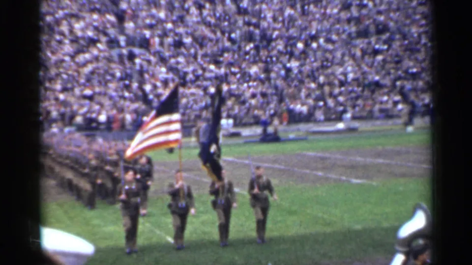 1944 San Francisco stadium scene showing soldiers with the American flag and a dark standard on the field before packed stands.