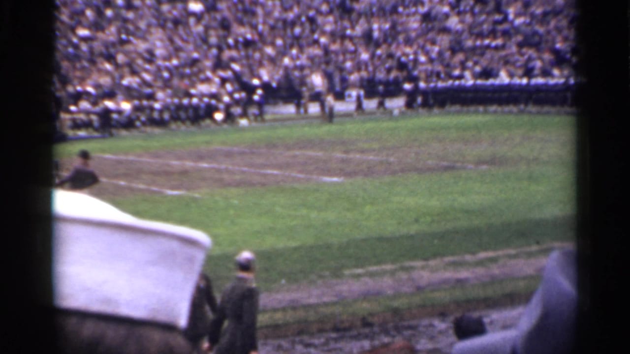 1944 San Francisco frame showing a wider stadium-field view with uniformed groups near the far sideline and spectators filling the stands.