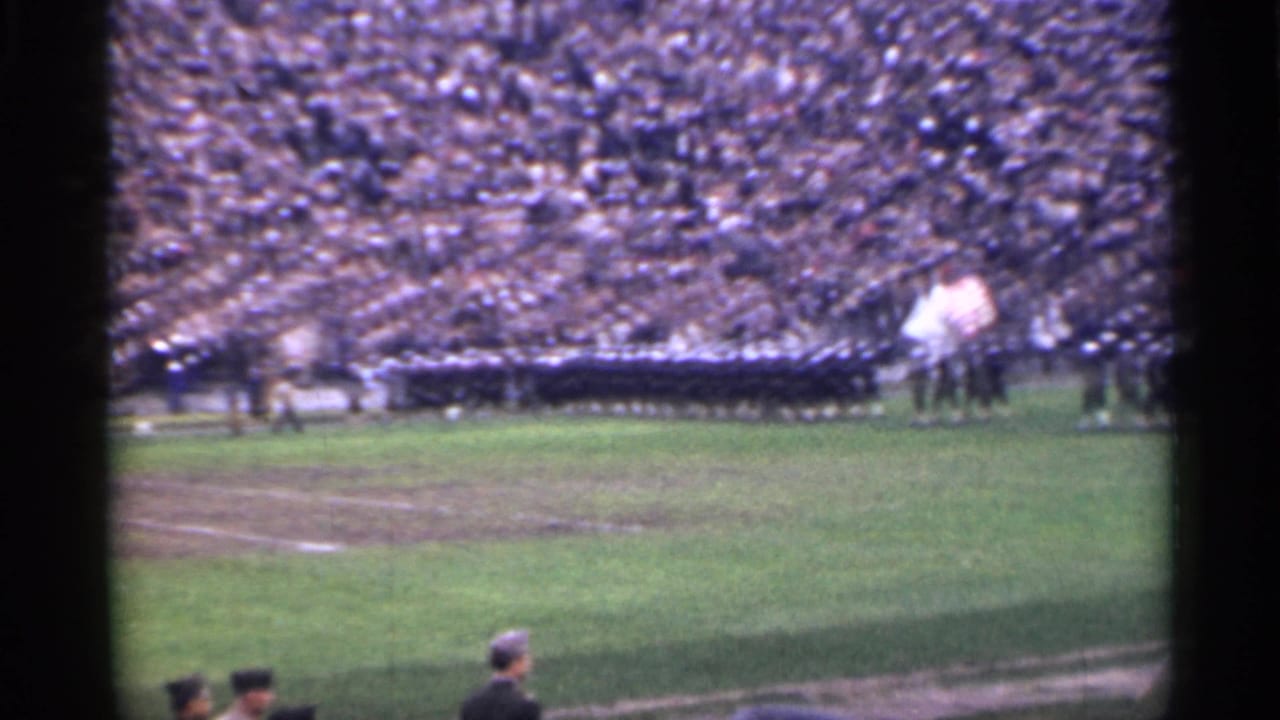 1944 San Francisco stadium view with dense stands, a broad grass field, uniformed personnel, and flags near the center-right distance.