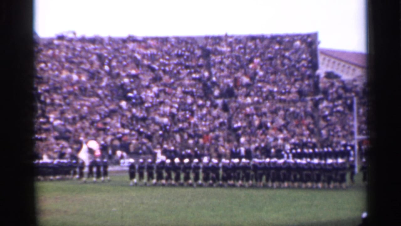 1944 San Francisco home-movie frame showing soldiers in formation on a stadium field with a dense crowd in the stands.