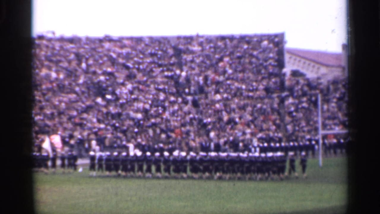 Stadium field view with uniformed soldiers in formation, a goalpost, and a large seated crowd in 1940s San Francisco footage.