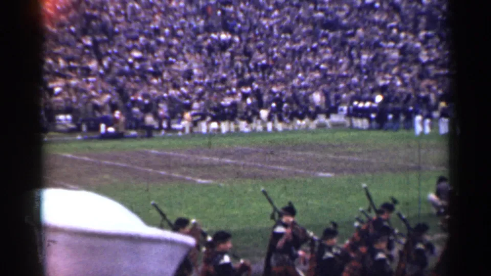1944 San Francisco stadium view with pipe band players near the camera and marching band members lined across the field.