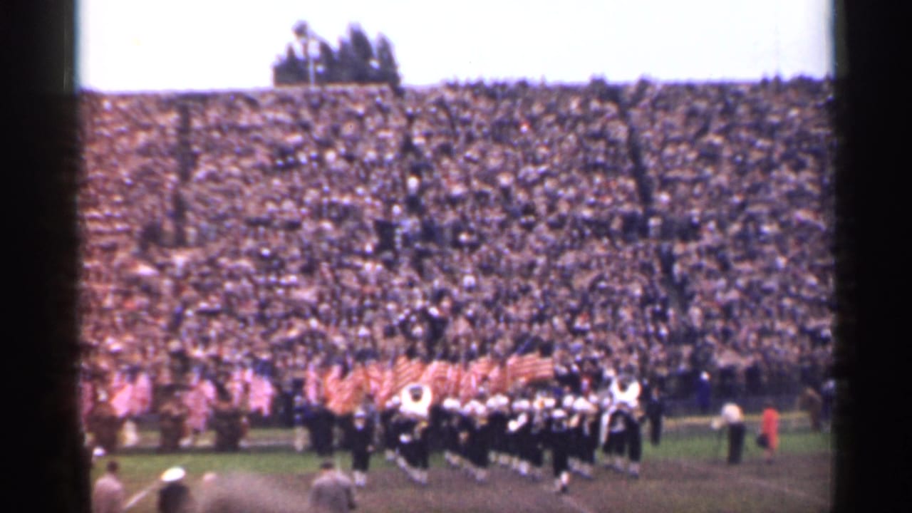 1944 San Francisco stadium footage with flag bearers and a dark-uniformed marching band performing before a large crowd.