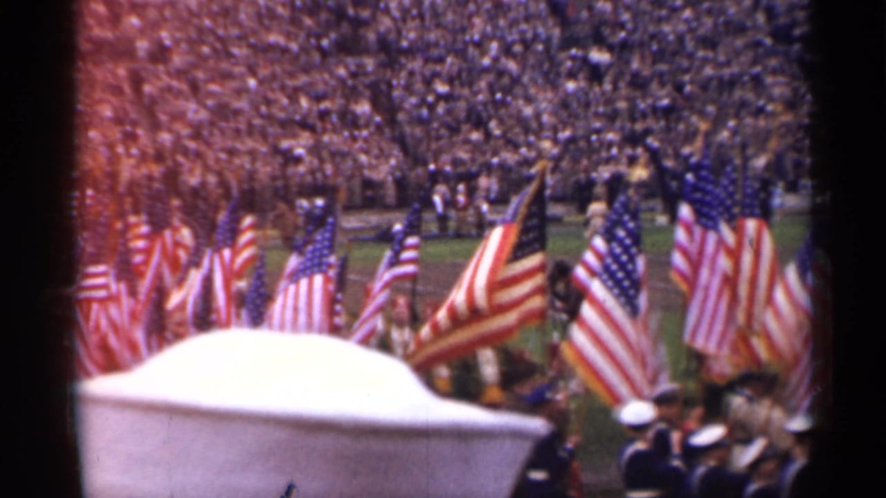 1944 San Francisco stadium ceremony with rows of American flags, uniformed figures, and a packed crowd seen from the stands.