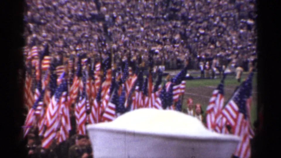 1944 San Francisco stadium view with American flags in formation, a large crowd in the stands, and a white barrier in the foreground.