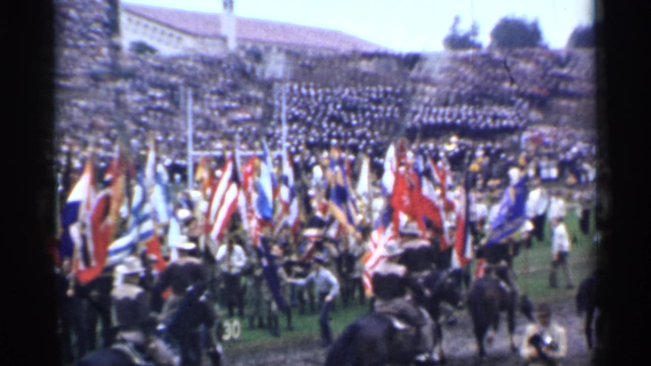 San Francisco 1944 home-movie frame showing flag bearers, horses, uniformed figures, and a packed stadium crowd.