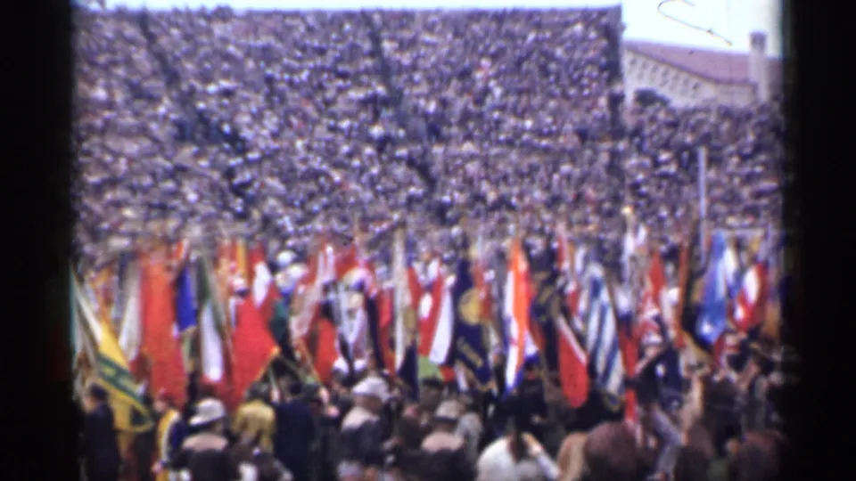 San Francisco 1944 frame showing a wide stadium crowd, many national flags, and people gathered on the field.