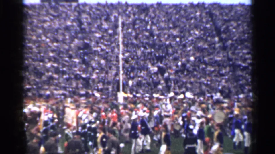 Color 8mm view of a San Francisco stadium crowd in 1944, with band activity clustered near the goalpost.