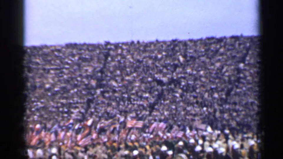 1944 San Francisco stadium footage showing American flags, band uniforms, and a dense spectator crowd.