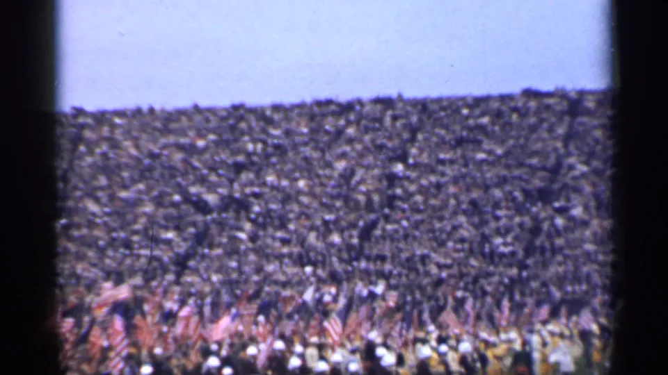 Distant 1944 San Francisco crowd footage showing flags, packed spectators, and visible 8mm frame artifacts.