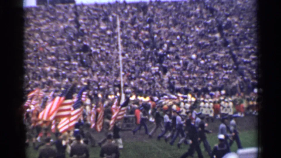 1944 San Francisco home-movie frame showing a field procession, American flags, and packed stadium seating.