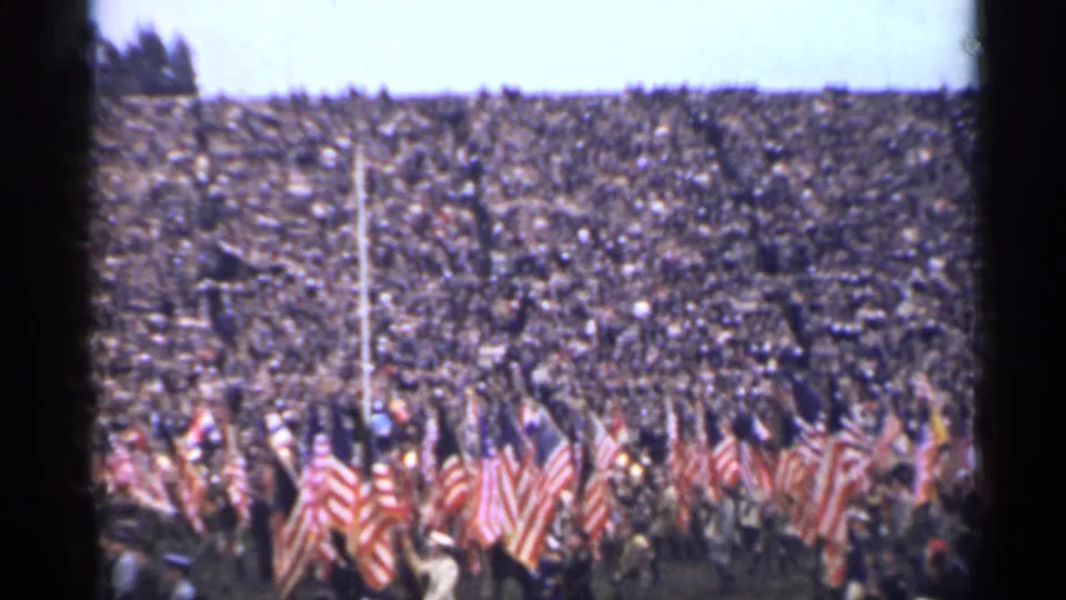 1944 San Francisco stadium scene with clustered American flags and spectators filling the bleachers behind them.