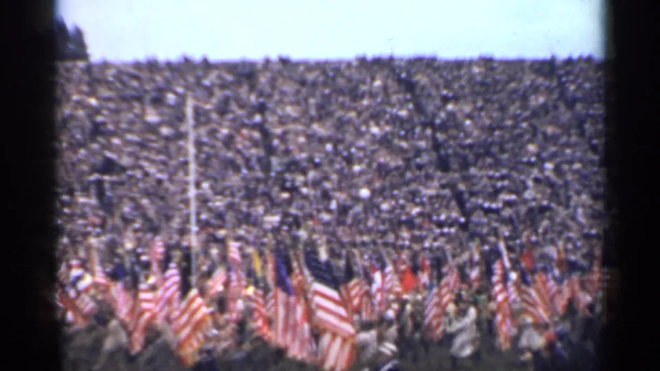 Mid-1940s home-movie view of flag bearers moving before a packed San Francisco stadium crowd.