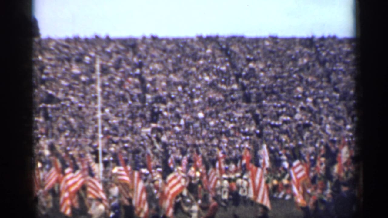 1944 San Francisco frame with a large stadium audience and multiple American flags visible in front of the stands.