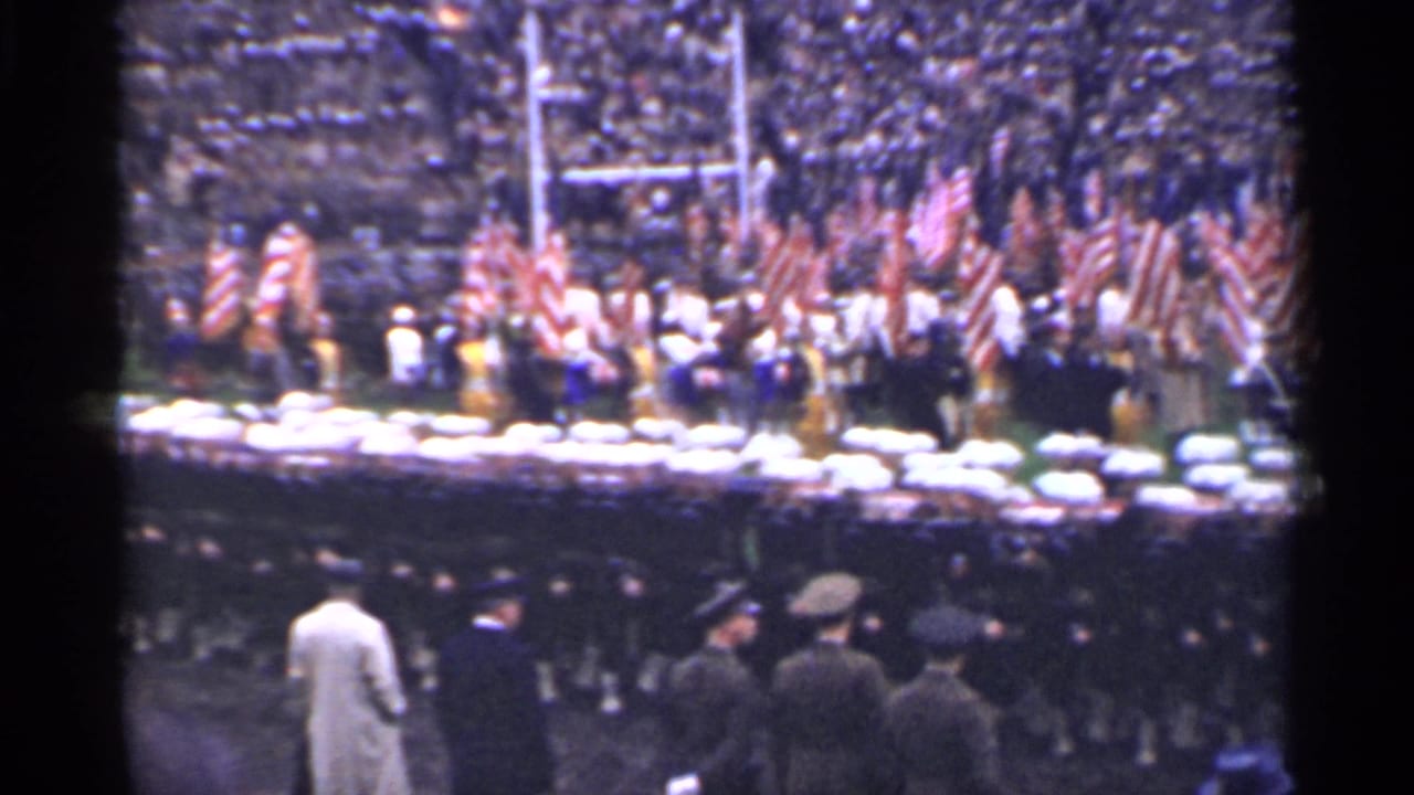 Wide 1944 San Francisco stadium view with a color guard, American flags, field officials, and uniformed personnel in formation.