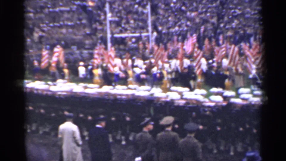 Wide 1944 San Francisco stadium view with a color guard, American flags, field officials, and uniformed personnel in formation.