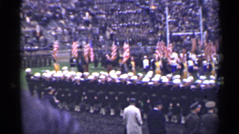 San Francisco 1944 8mm frame showing uniformed personnel at attention before American flags and a large stadium audience.