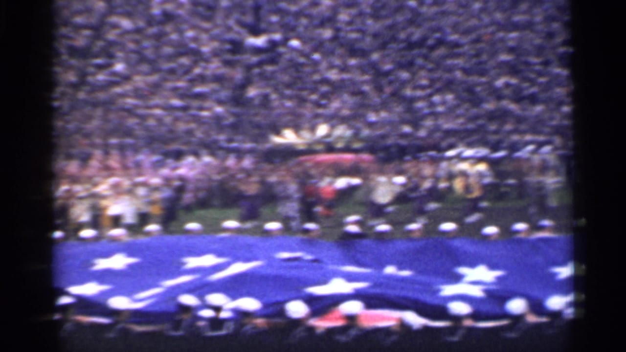 1944 San Francisco home-movie view of uniformed personnel holding a large American flag on a stadium field before crowded stands.