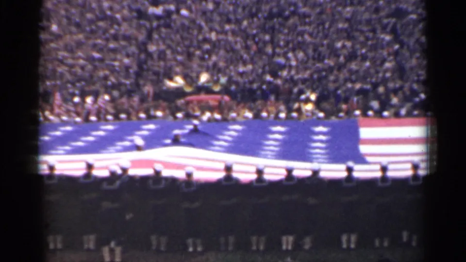 A wider 1944 San Francisco stadium view shows the massive U.S. flag spread across the field before a packed audience.