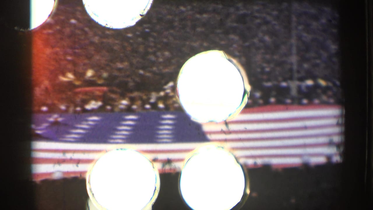 1944 San Francisco frame with the field flag and stadium crowd partly interrupted by bright flare marks from the film scan.
