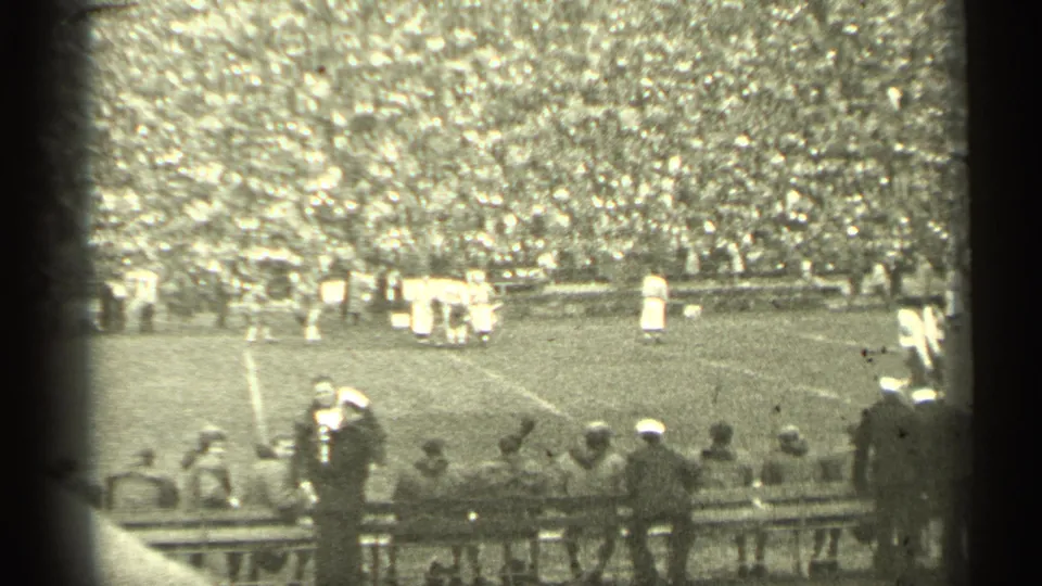 1944 San Francisco home-movie view of a football game from the stands, with players on the field and spectators lining the lower edge.