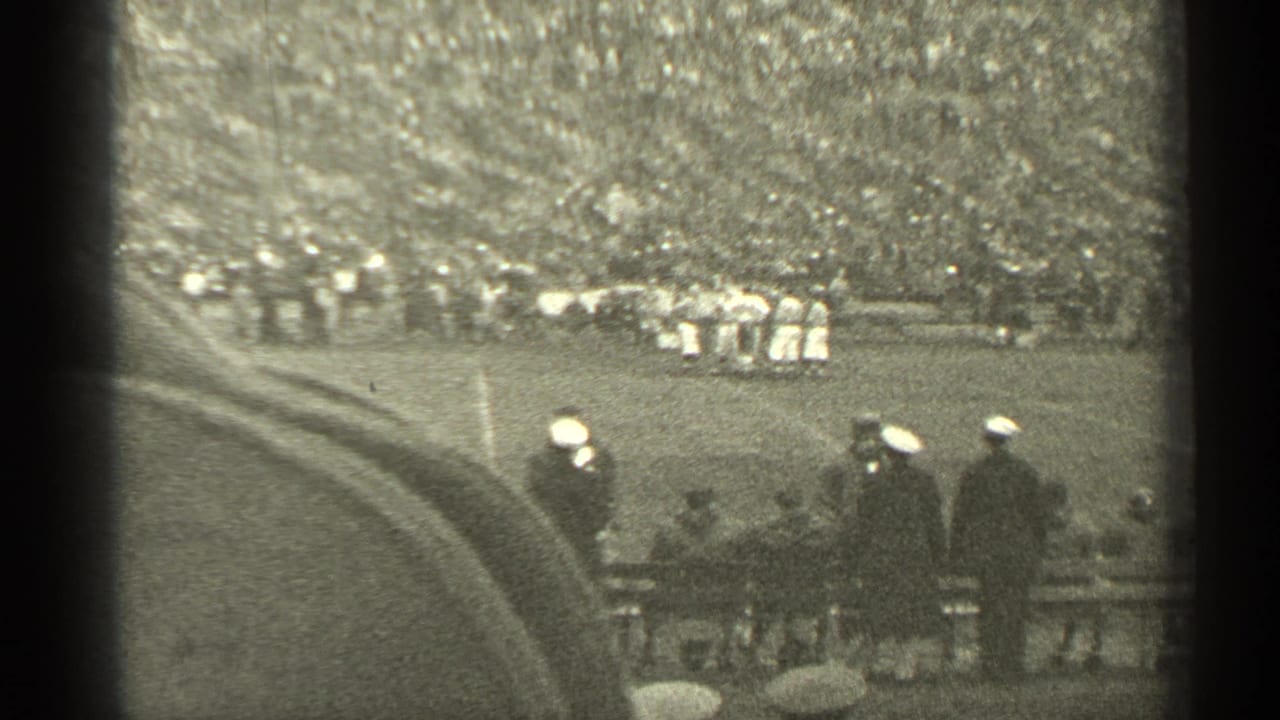 1944 San Francisco stadium view with football players in the distance, a curved walkway, and men in caps watching from the sideline.