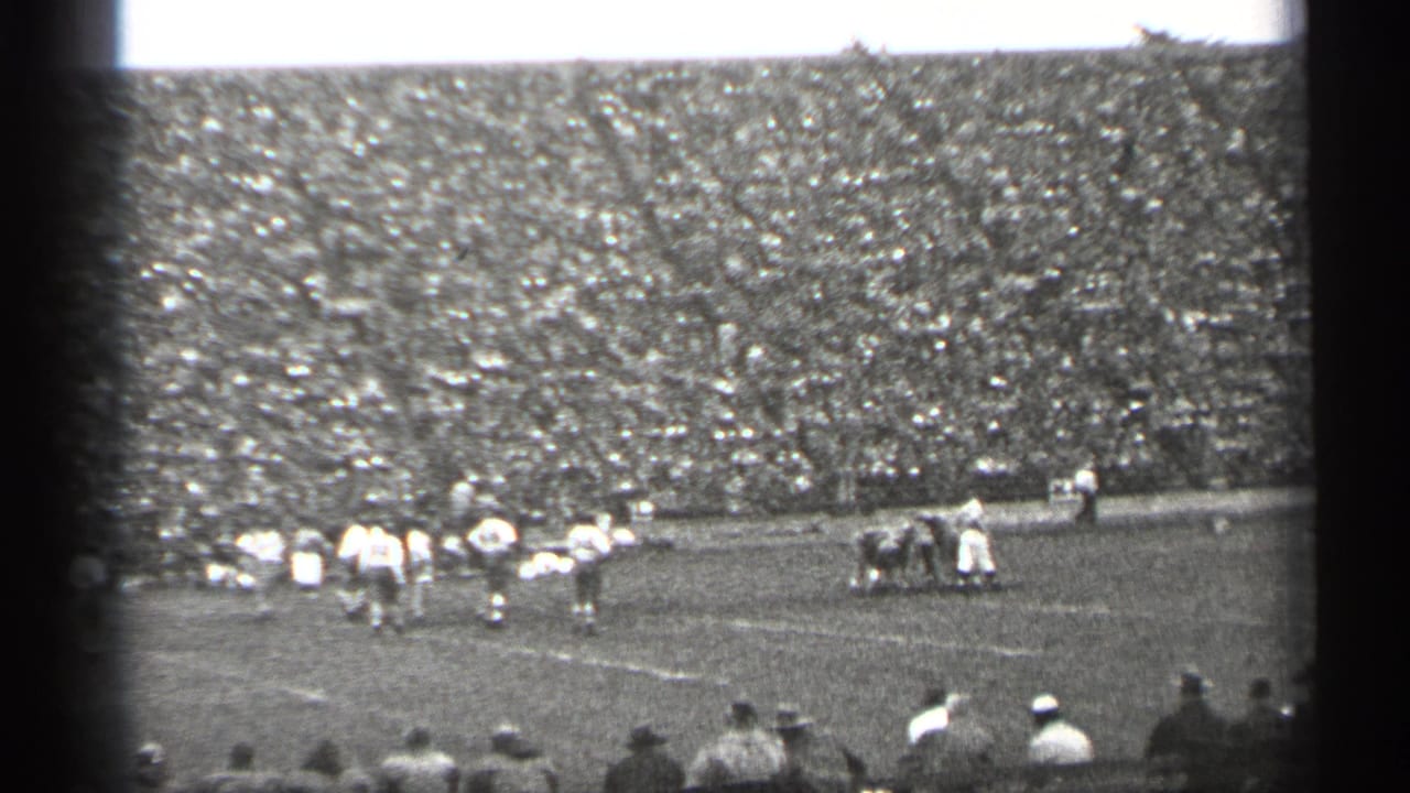 1944 San Francisco footage frame with players spread across the field and a packed stadium crowd in the background.