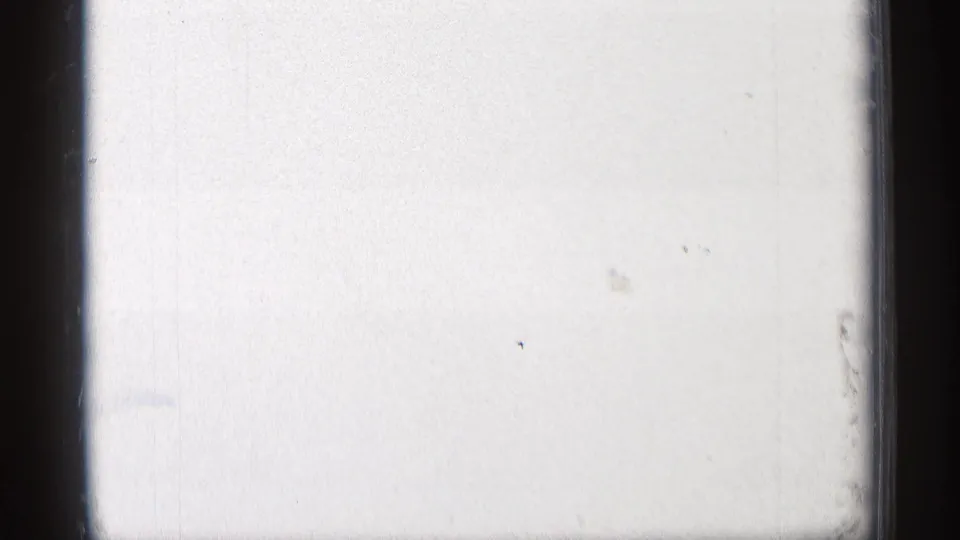 Overexposed end frame from the 8mm scan, showing pale film area, faint surface marks, and a dark vertical gate edge.