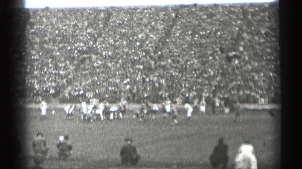 1944 San Francisco home-movie view of football players on the field with a large crowd filling the stands behind them.