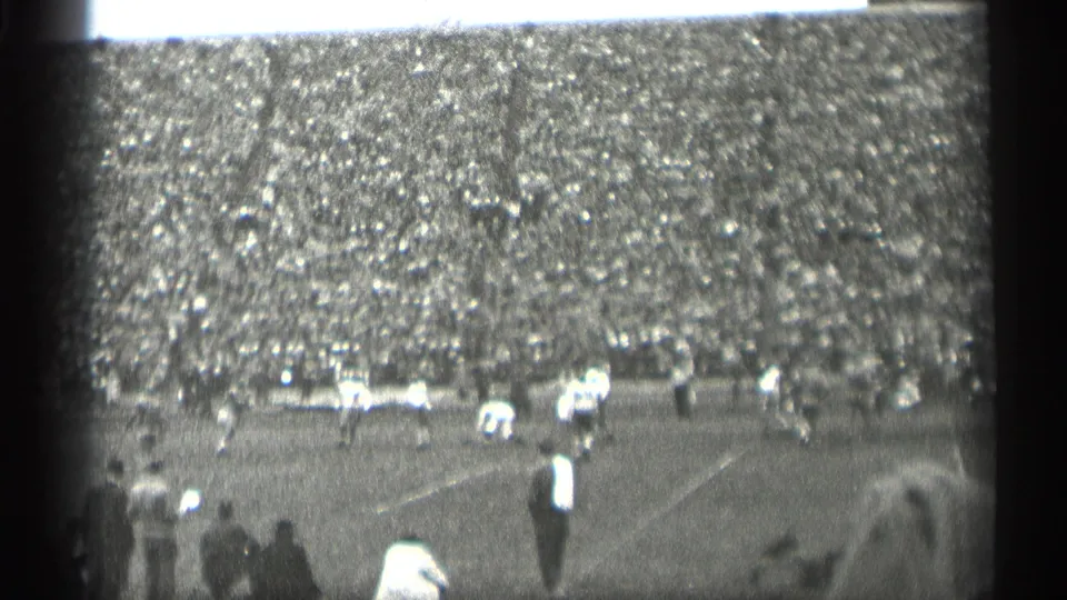 Wide 1944 San Francisco stadium view with football players on the field, sideline observers, and a dense crowd across the grandstand.