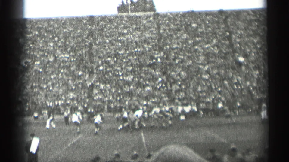 Mid-1940s 8mm stadium view in San Francisco, showing football players near the sideline and a broad crowd-filled grandstand.