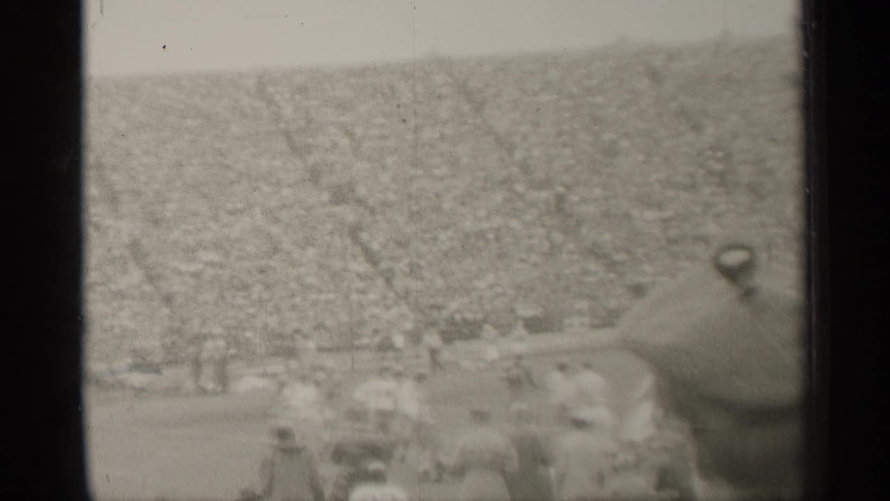 A soft 1944 San Francisco stadium view shows football players and a dense crowd from a spectator position.