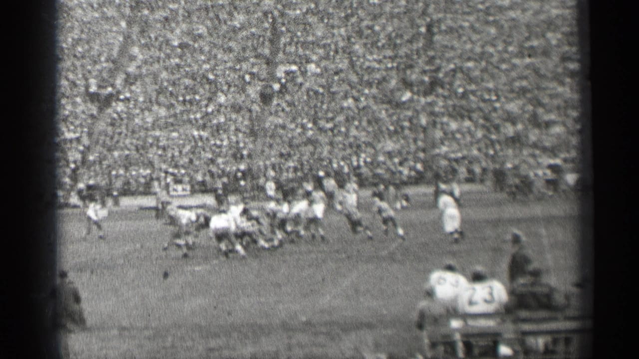1944 San Francisco stadium view with a football tackle or pile-up near the center of the field and spectators filling the background.