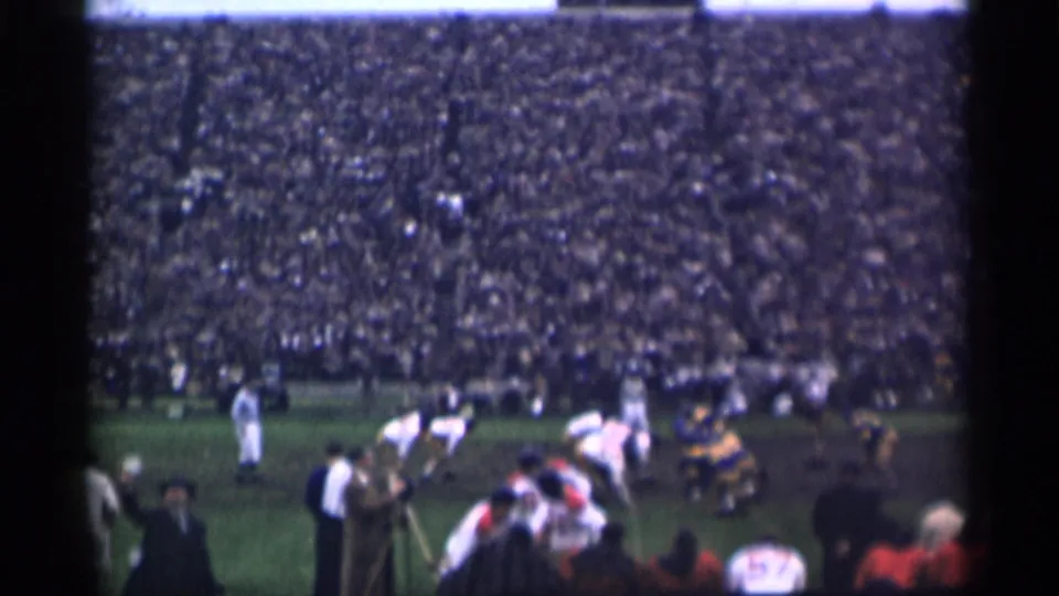 1944 San Francisco stadium footage showing football players near the line of scrimmage, sideline spectators, and packed seating.