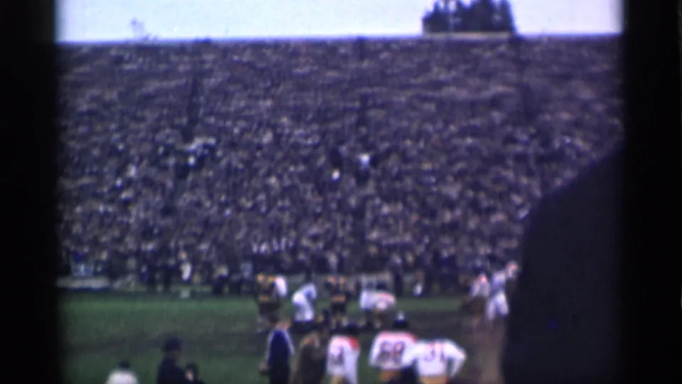 Wide 1944 San Francisco home-movie view of a football field, sideline activity, and crowded stadium seating.