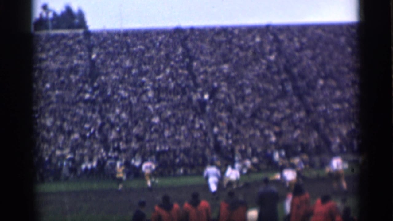 A spectator view of a 1940s San Francisco football game, with play underway and a large crowd in the background.