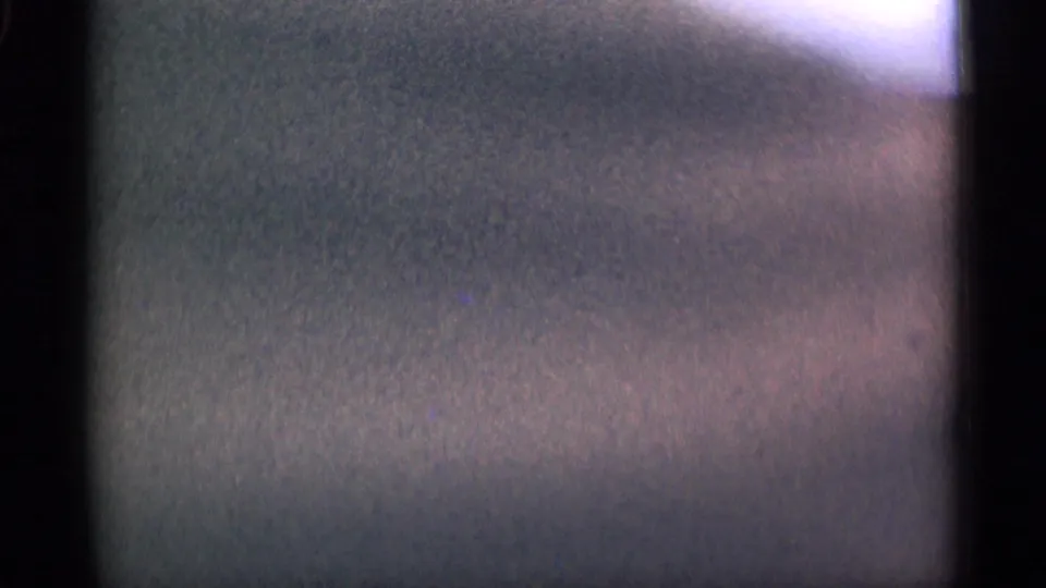 Soft, obstructed 8mm frame from the 1944 San Francisco stadium clip, with only vague color and field shapes visible.