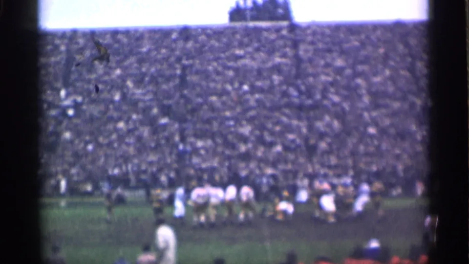 Wide 1944 San Francisco stadium view with football players lined across the field and a packed grandstand filling the background.
